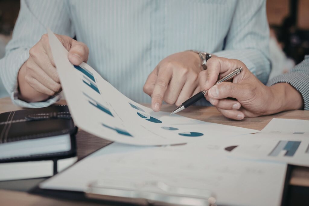 Business professionals reviewing financial charts and documents on a desk, representing commercial lending and property investment strategy.